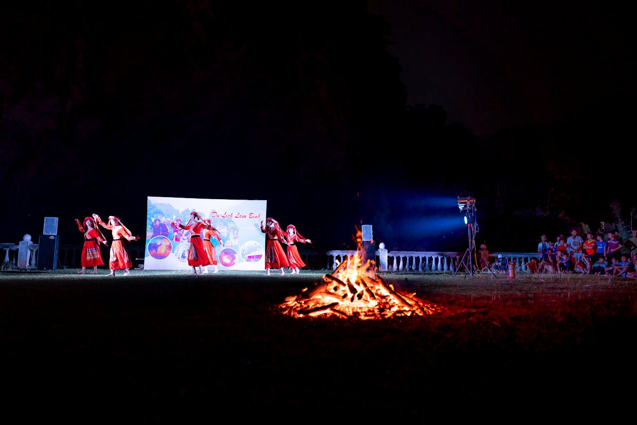 An outdoor night festival featuring traditional dance performances and a bonfire.